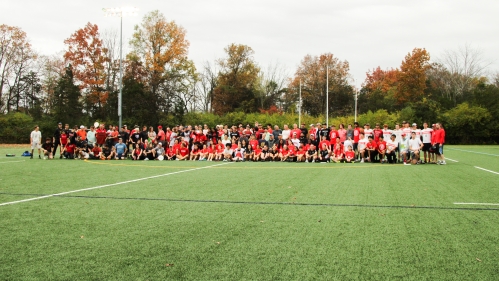Current Rutgers Ultimate players, alumni, and their families pose for a photo at the 50th Anniversary Game