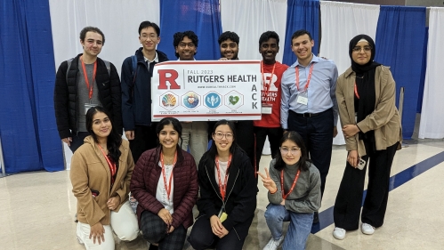 IDEA students pose with Rutgers Health sign