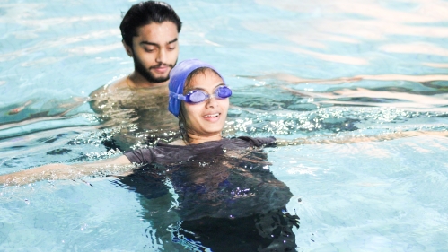 A swim instructor helps a participant at the Spring 2024 Swim School