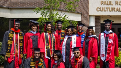 group of graduating students in front of Paul Robeson Cultural Center on Busch Campus 
