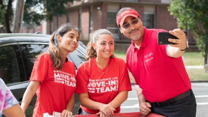 Salvador Mena, vice chancellor for student affairs at Rutgers University-New Brunswick, takes a selfie with two students moving in on campus