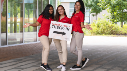 students hold check-in sign
