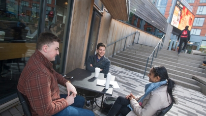 students Kyle Bright (SAS '19), Samuel Vlaimirsky (SAS '19) and Priyanka Bhatt (SAS '19) enjoy a cup of coffee outside Starbucks at The Yard