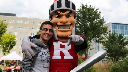 student poses with Scarlet Knight mascot on Voorhees Mall on College Avenue Campus