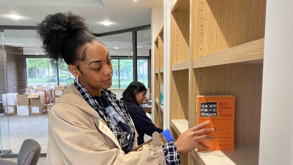 Rutgers graduate student Jassadi Moore and undergraduate Stephanie Lopez-Perez add books from Cheryl A. Wall’s collection to the shelves of a new reading room