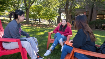 Thi Tran (SAS ’23), Samantha Eng (SEBS ’23), and Thalia Lantin (SAS ’23) sit and talk outside on the Livingston Campus