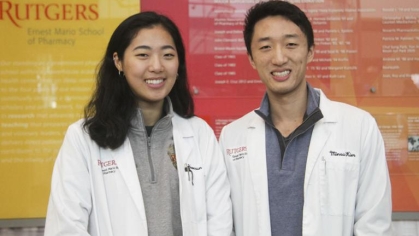 two students wear Rutgers lab coats