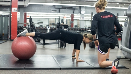 Rutgers personal trainer works with a client in a gym