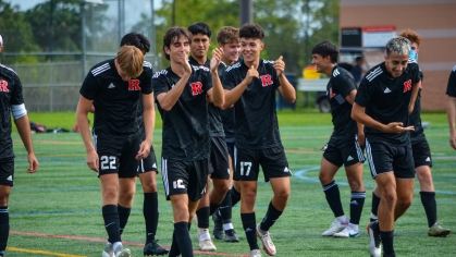 Rutgers Club soccer players celebrate while walking off the field