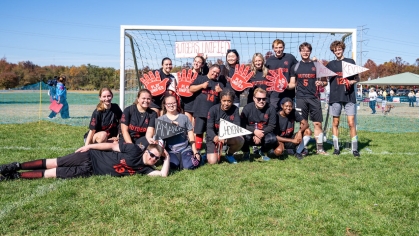 Rutgers Unified team poses in front of a soccer goal
