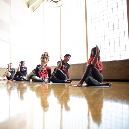 students doing yoga with Scarlet Knight mascot