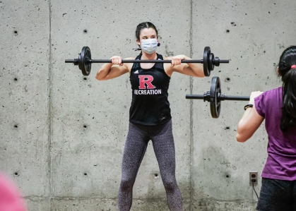 fitness instructor leads a weight-lifting class at Rutgers Recreation
