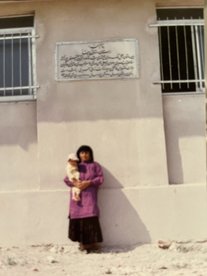 Hariri's mother standing under the plaque