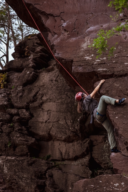 A participants climbs a cliff during a GO Outdoors trip