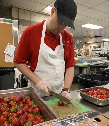 Chris chops strawberries at Busch Dining Hall