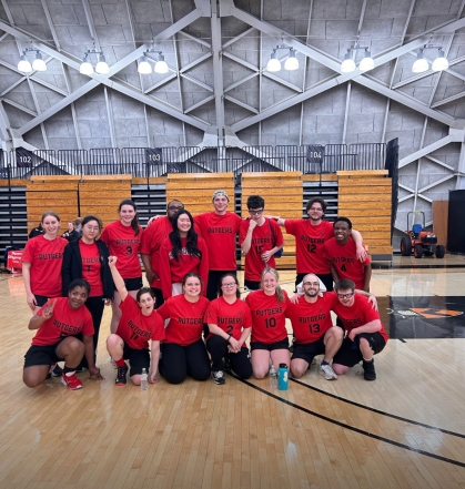 The Rutgers Unified team poses for a photo on a basketball court.